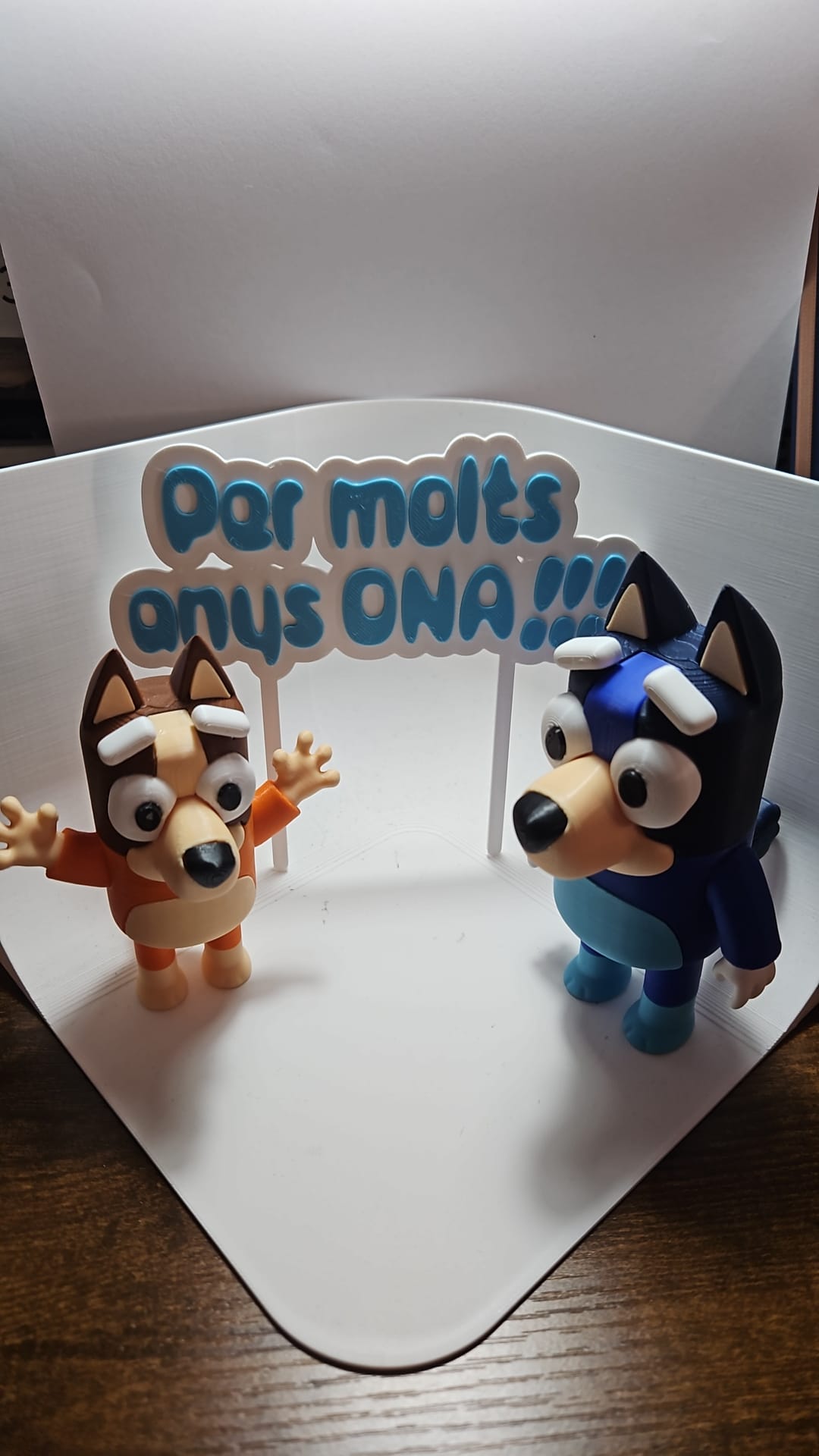 Topper 'Per molts anys ONA!!!' en azul con figuras de Bluey y Bingo impresas en 3D