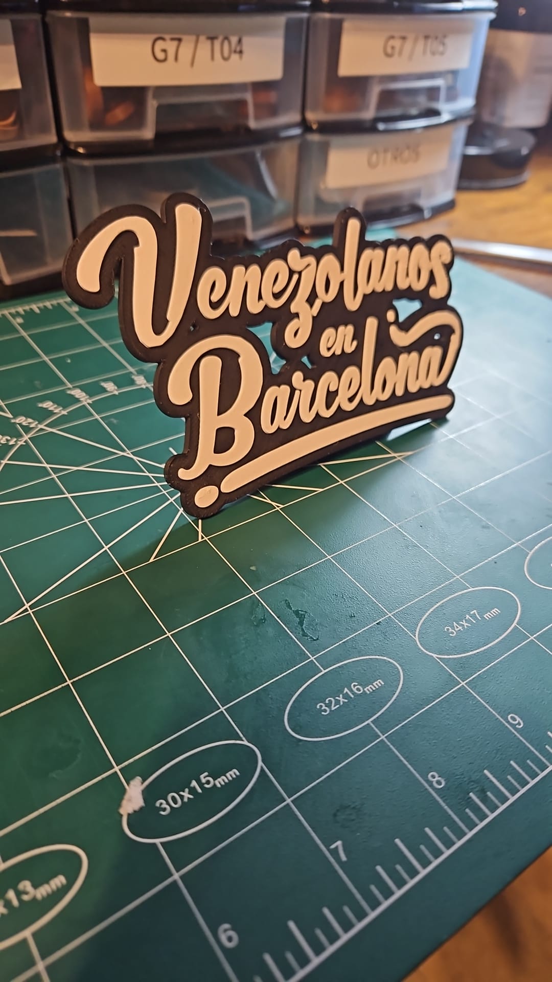 Cartel de sobremesa impreso en 3D Venezolanos en Barcelona en blanco sobre negro