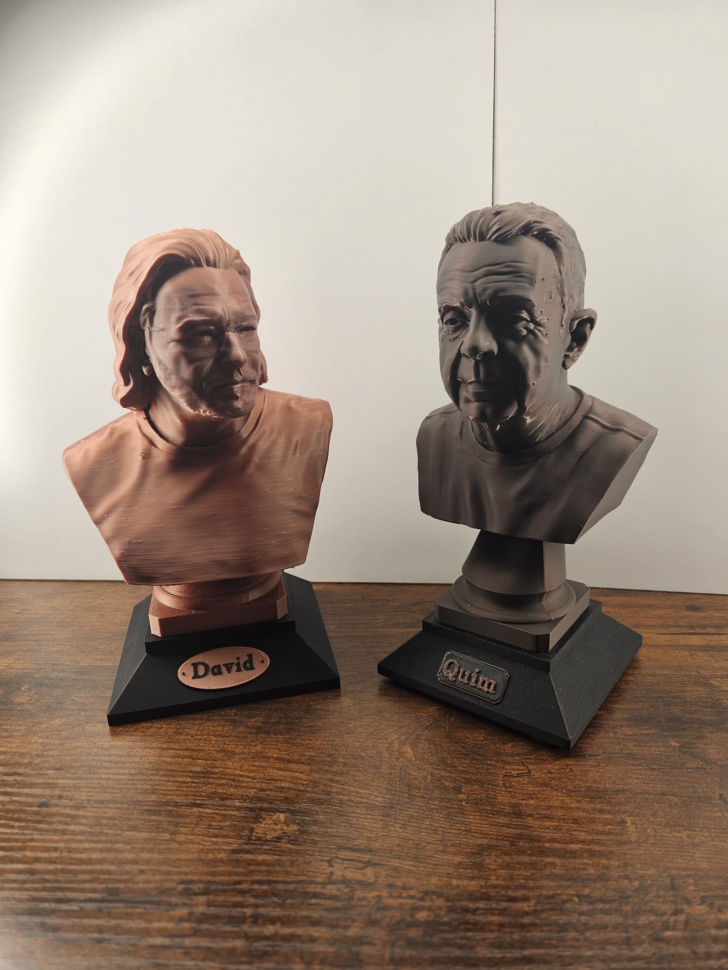 Dos bustos personalizados con peana negra y placa con nombre (David en cobre, Quim en bronce oscuro)